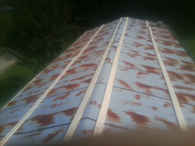 Rusted metal roof panels with new wood purlins before replacement — Storm Damage Roof Repair in Conneaut Lake by Roofing Brothers