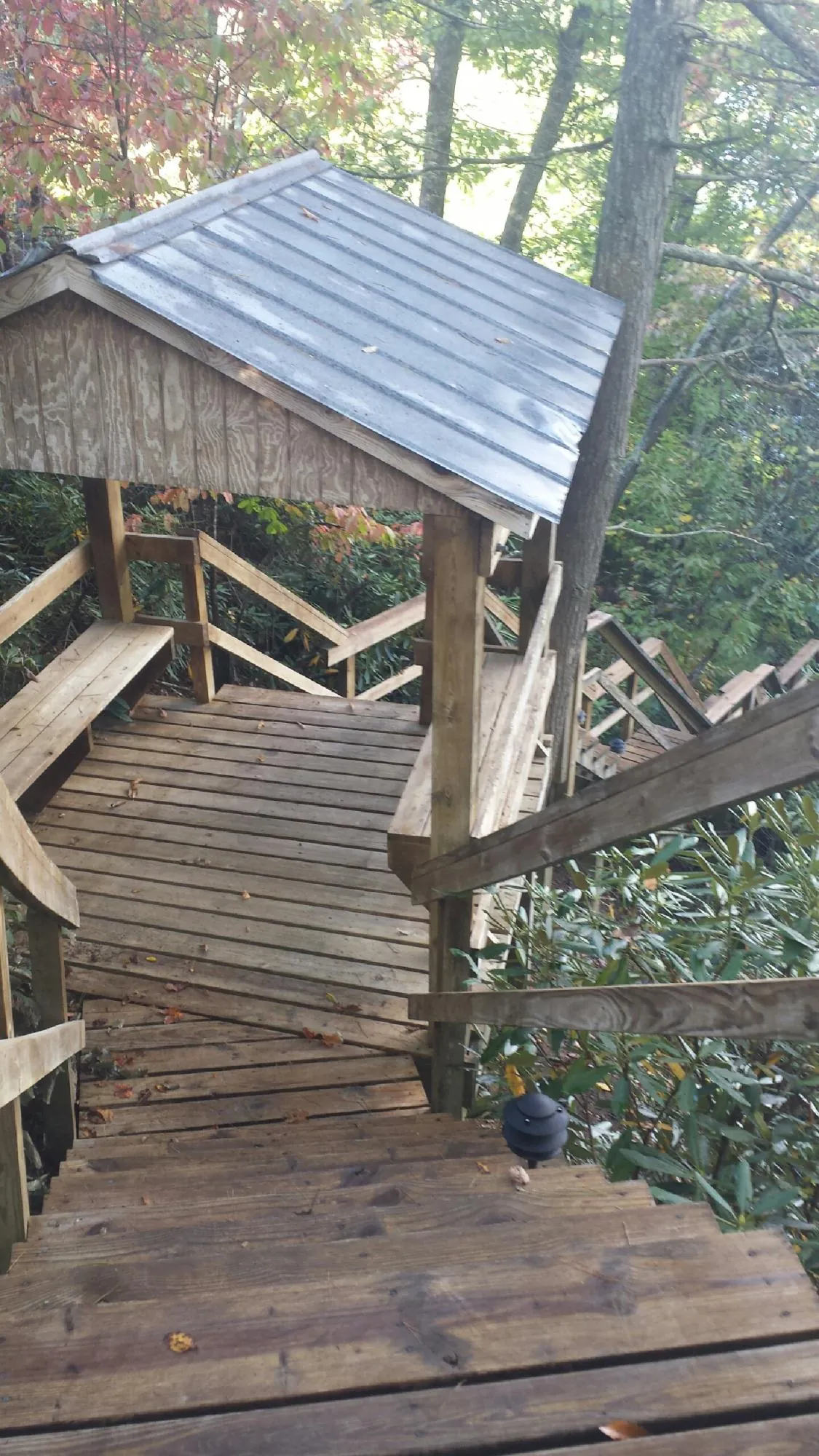 Metal roofed shelter over wooden steps on a wooded walkway — Skylight Repair & Installation work by our crew in Conneaut Lake