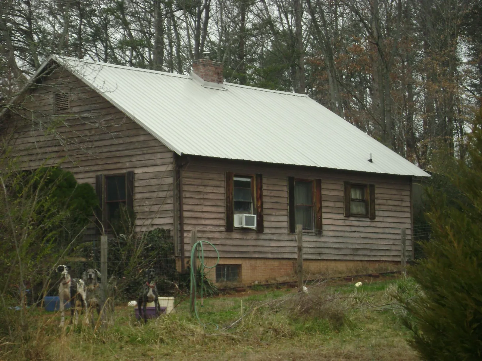 White metal roof on an old wood sided farmhouse, from a Metal Roof Installation job in Conneaut Lake